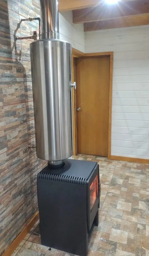 Termocañón de acero inoxidable instalado sobre una estufa a leña